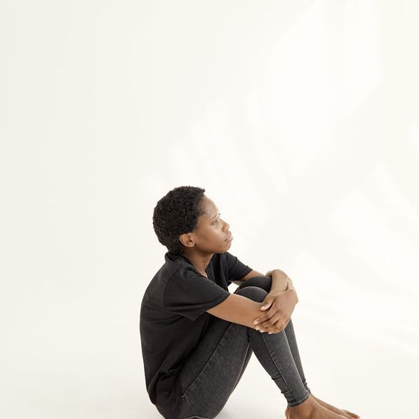 A person sitting calmly with a serene expression, embodying wellbeing.